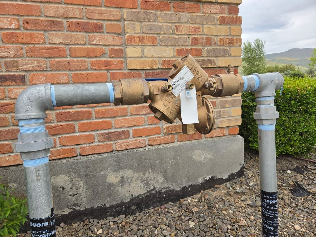 Idaho Backflow tagged backflow preventer on a brick exterior install